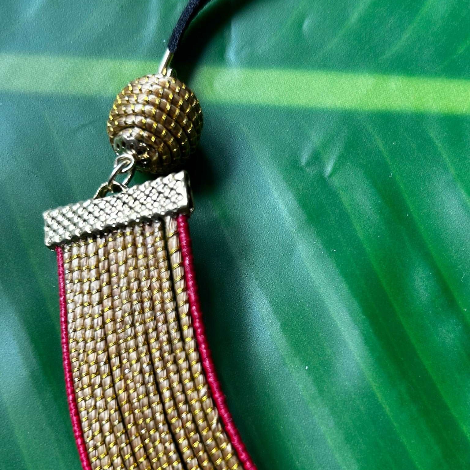 Collier Capim Dourado orné d'une bordure en fibre de palmier buriti teintée en rouge