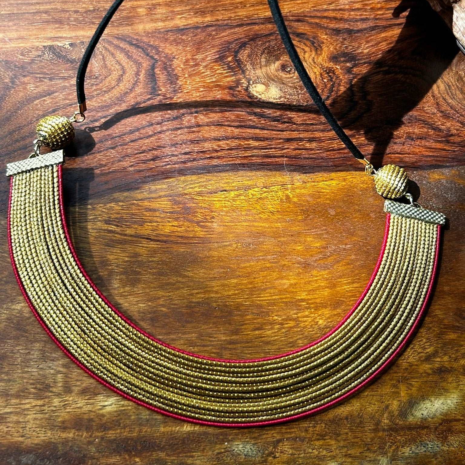 Collier Capim Dourado orné d'une bordure en fibre de palmier buriti teintée en rouge