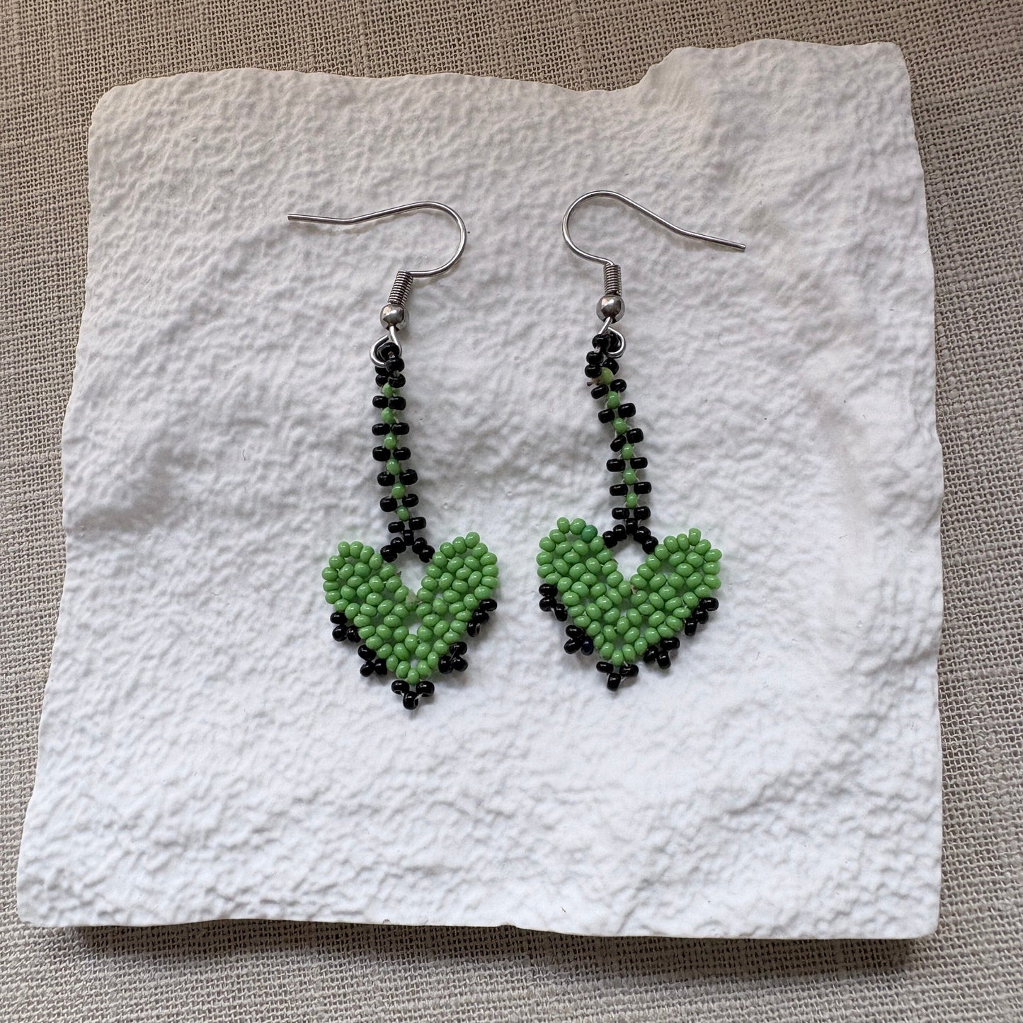 Boucles d'oreilles en perles de verre - Cœur vert et noir - Ethnie Marubo Boucles d'oreilles Ethnie Marubo, localisée dans l'état d'Amazonas au nord du Brésil.