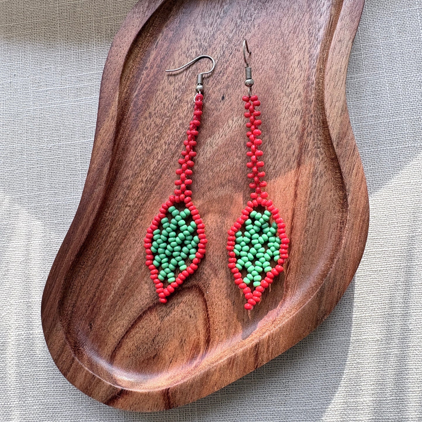 Boucles d'oreilles en perles de verre - Feuille - vert et rouge - Ethnie Marubo Boucles d'oreilles Ethnie Marubo, localisée dans l'état d'Amazonas au nord du Brésil.