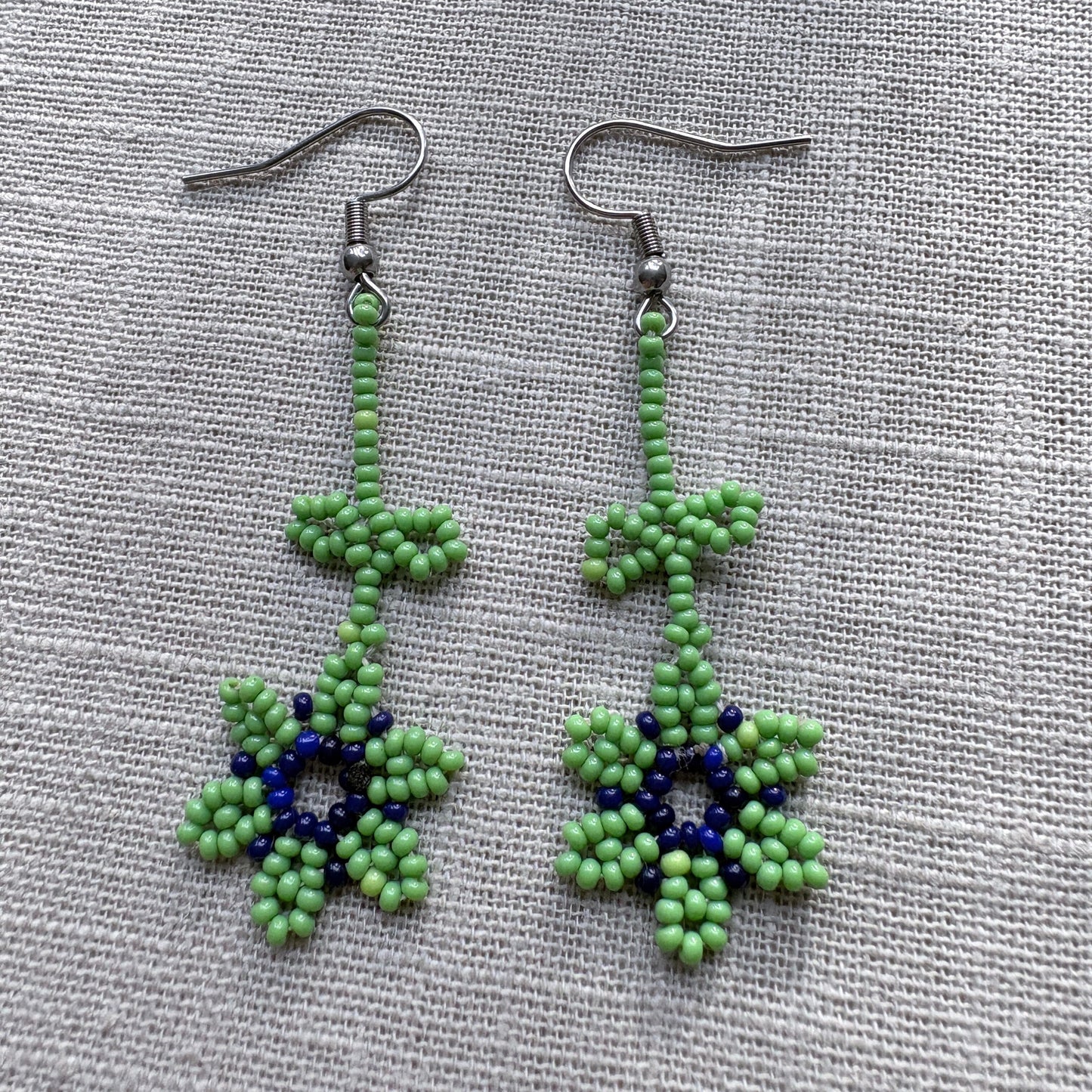 Boucles d'oreilles en perles de verre - Fleur - vert et bleu - Ethnie Marubo Boucles d'oreilles Ethnie Marubo, localisée dans l'état d'Amazonas au nord du Brésil.
