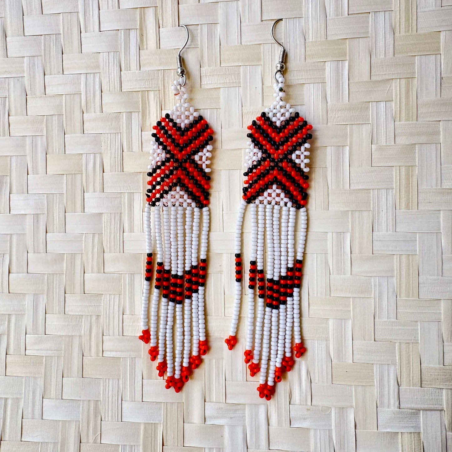Boucles d'oreilles en perles de verre (miçanga) - blanc croix noir et orange - Ethnie Wai Wai Boucles d'oreilles Ethnie Wai Wai localisée dans les états de l' Amazonas, Pará et Roraima dans le Nord du Brésil.