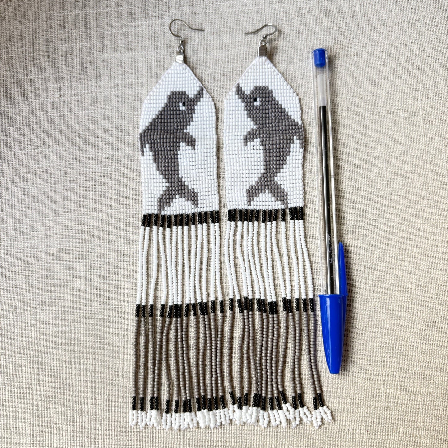 Boucles d'oreilles en perles de verre (Miçanga) - Dauphin gris - Ethnie Borari Boucles d'oreilles Ethnie Borari, localisée dans l'état du Pará dans le Nord du Brésil.