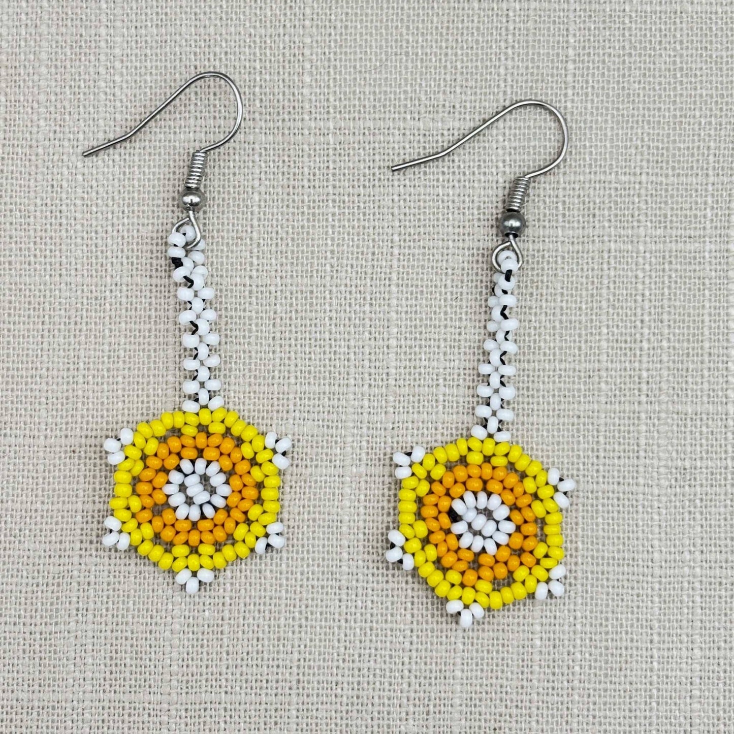 Boucles d'oreilles en perles de verre (miçanga) - Fleur blanche jaune et orange - Ethnie Wai Wai Boucles d'oreilles Ethnie Wai Wai localisée dans les états de l' Amazonas, Pará et Roraima dans le Nord du Brésil.