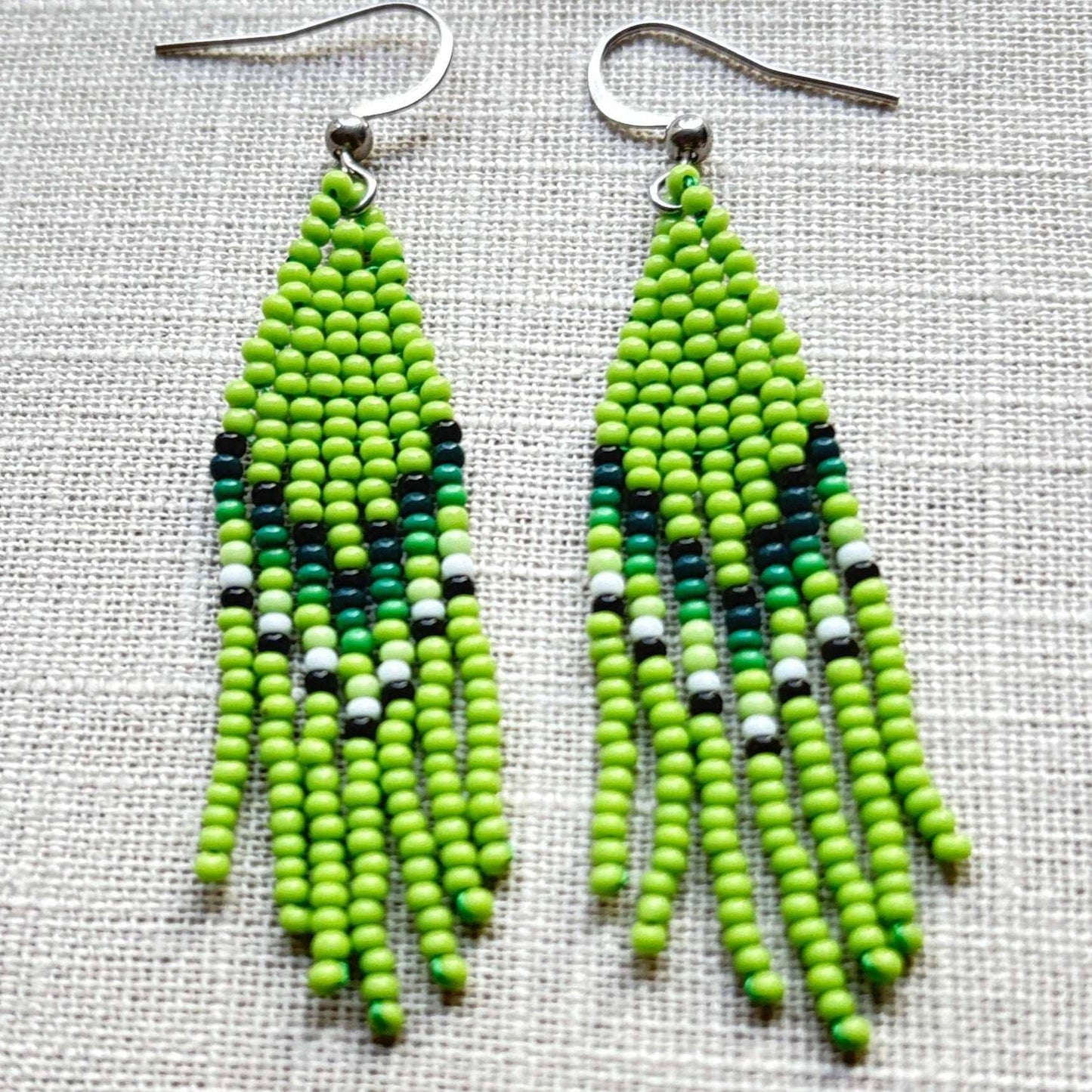 Boucles d'oreilles en perles de verre (Miçanga) - Franges vert blanc - Ethnie Borari Boucles d'oreilles Ethnie Borari, localisée dans l'état du Pará dans le Nord du Brésil.