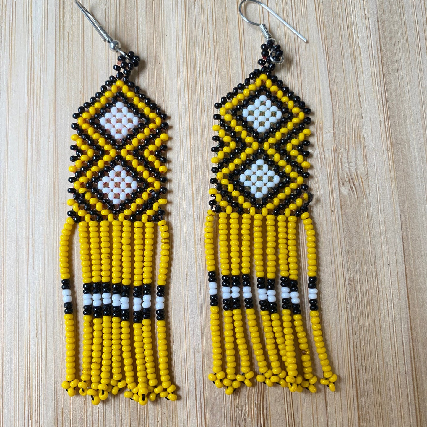 Boucles d'oreilles en perles de verre (miçanga) - jaune noir et losanges blancs - Ethnie Wai Wai Boucles d'oreilles Ethnie Wai Wai localisée dans les états de l' Amazonas, Pará et Roraima dans le Nord du Brésil.