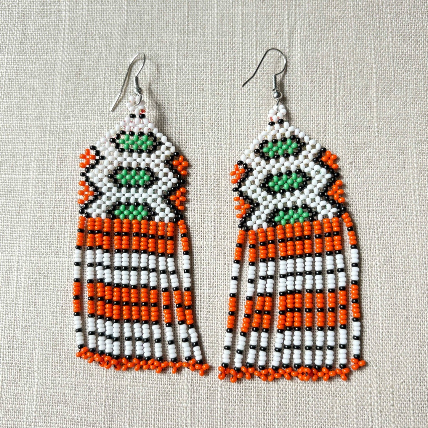 Boucles d'oreilles en perles de verre (miçanga) vert, blanc et orange Boucles d'oreilles Ethnie Wai Wai localisée dans les états de l' Amazonas, Pará et Roraima dans le Nord du Brésil.