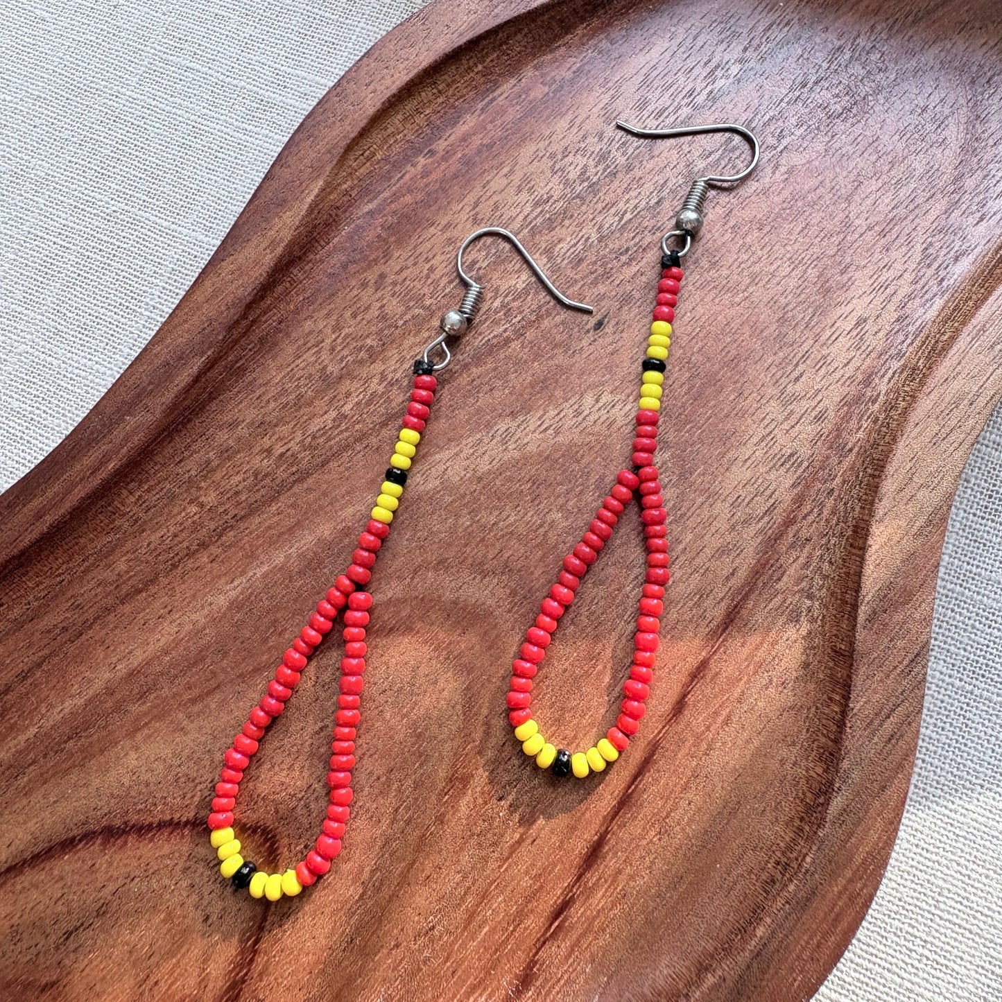 Boucles d'oreilles en perles de verre - Rouge jaune et noir - Ethnie Marubo Boucles d'oreilles Ethnie Marubo, localisée dans l'état d'Amazonas au nord du Brésil.