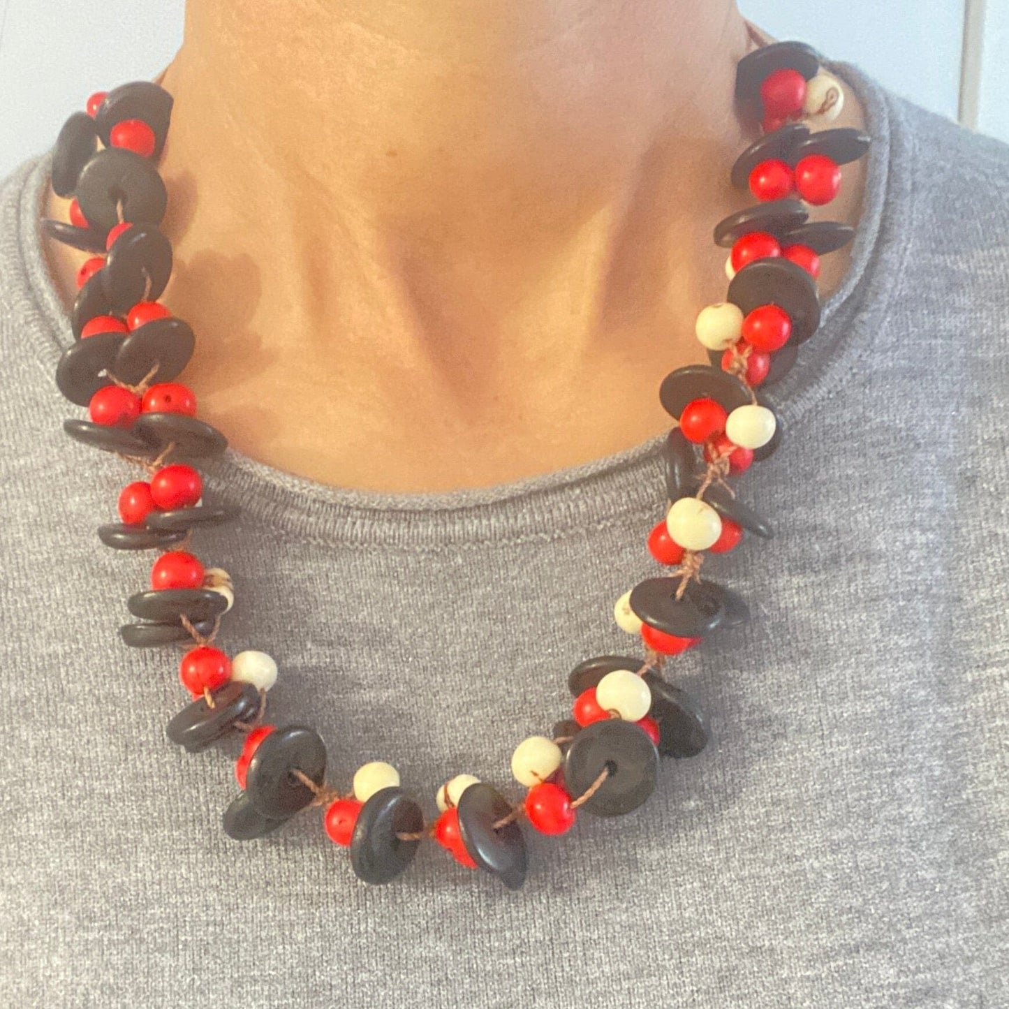 Collier de graines d'açai blanches et rouges et noix de coco