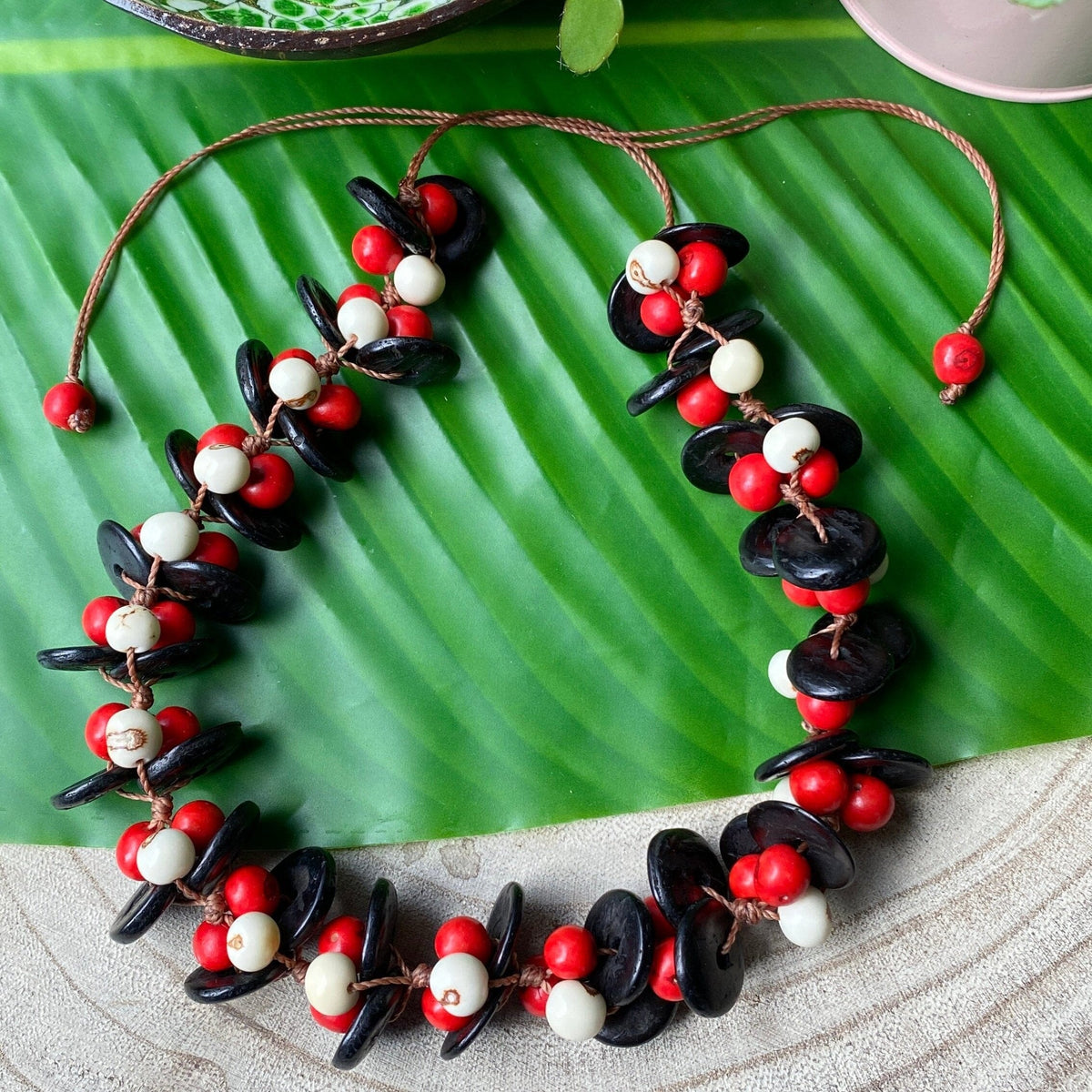 Collier de graines d'açai blanches et rouges et noix de coco