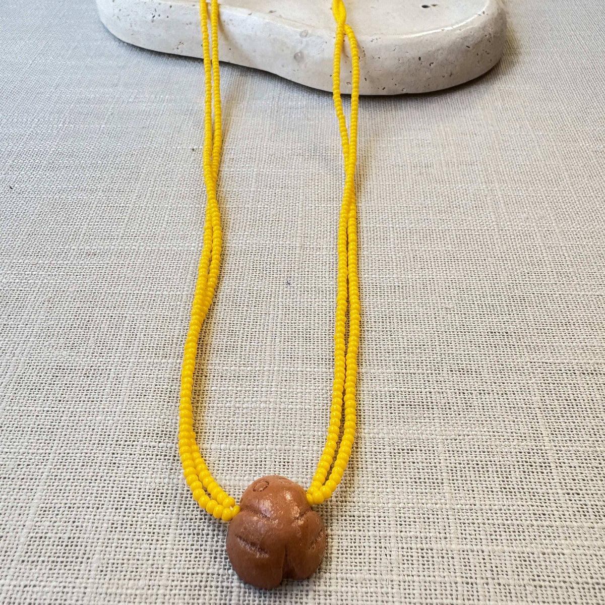 Colar em contas de vidro (Miçanga) - amarelo e pingente Muiraquitã