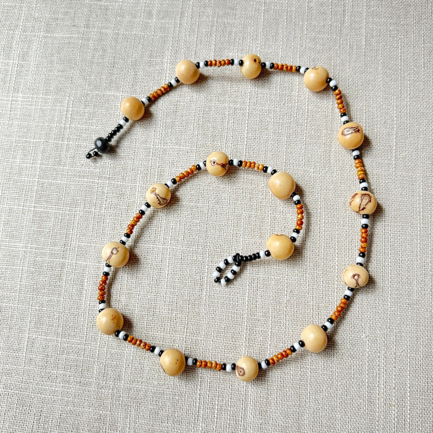 Collier en perles de verre (miçanga) marron noir et blanc et graines d'açai - Ethnie Wai Wai Collier Ethnie Wai Wai localisée dans les états de l' Amazonas, Pará et Roraima dans le Nord du Brésil.