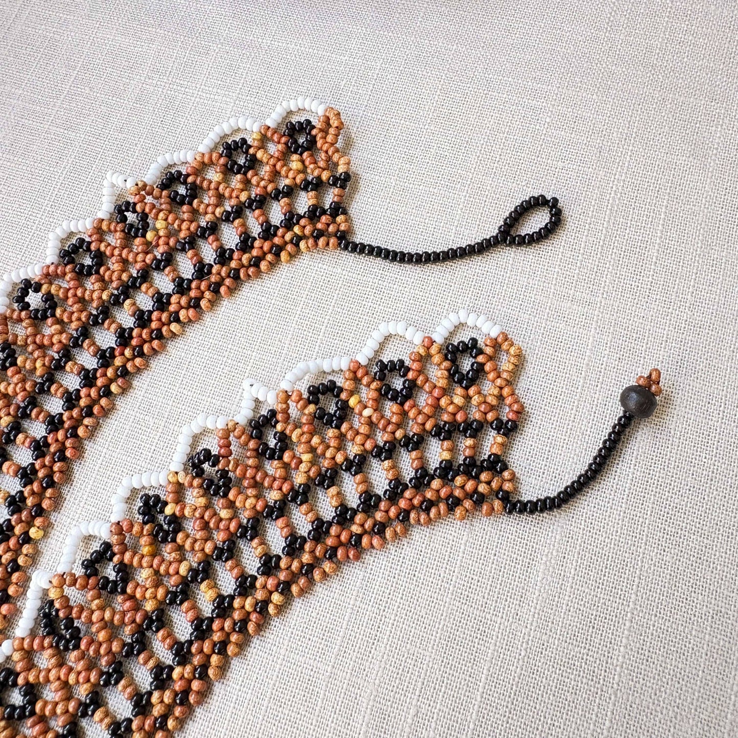 Collier en perles de verre (miçanga) ras de cou marron noir blanc et beige - Ethnie Wai Wai Collier Ethnie Wai Wai localisée dans les états de l' Amazonas, Pará et Roraima dans le Nord du Brésil.