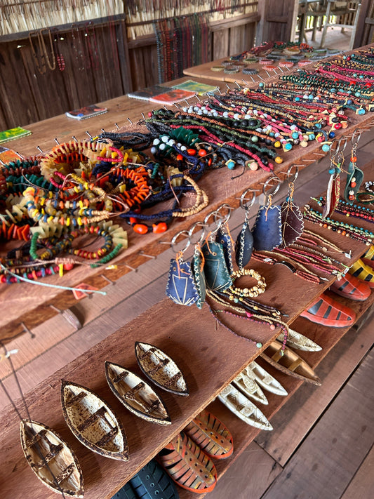 Étal de colliers, bracelets et objets artisanaux dans un espace en bois