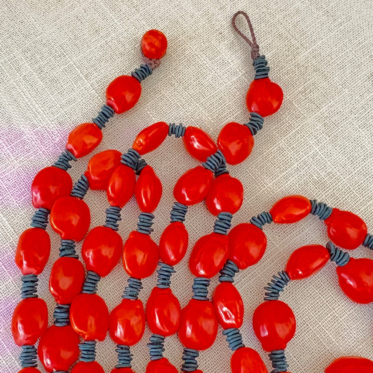 Collier de graines de morototo vert et tento rouge