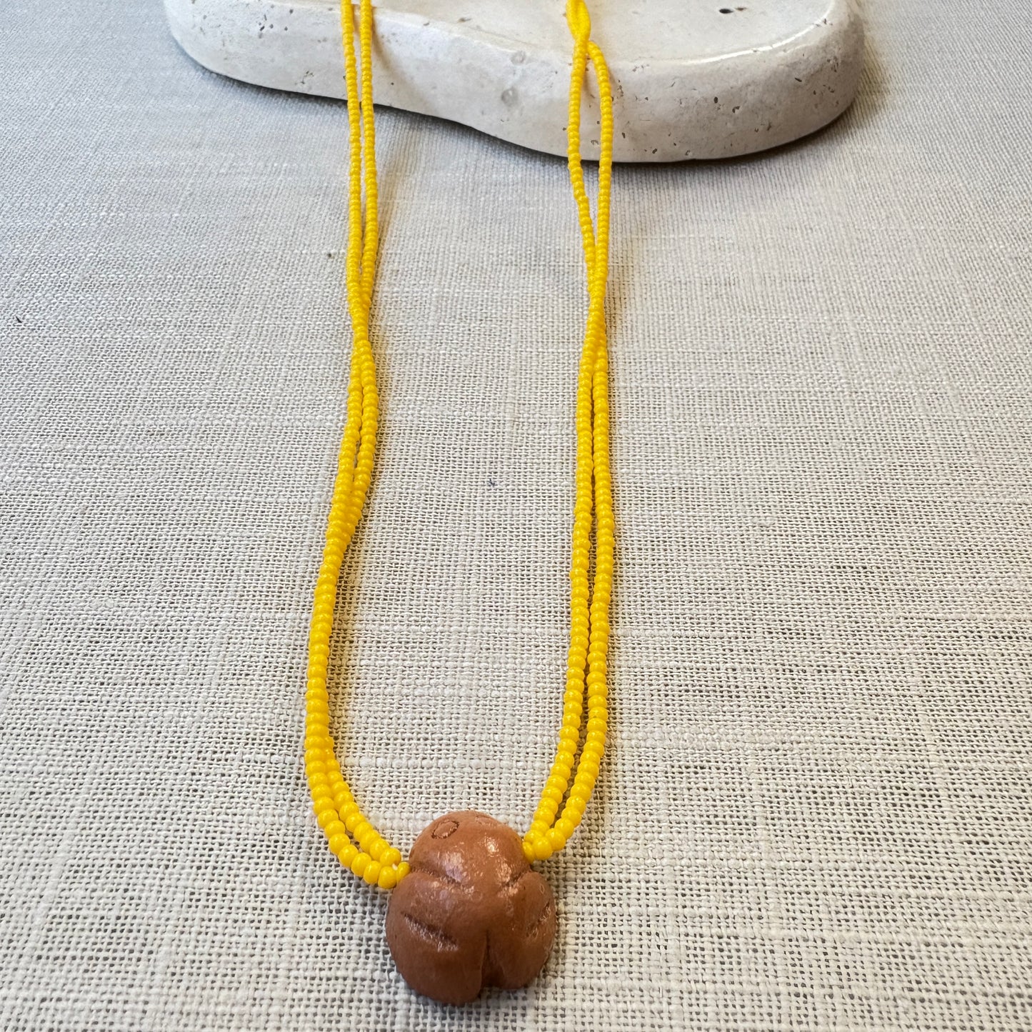 Collier en perles de verre (Miçanga) - jaune et pendentif Muiraquitã - Ethnie Borari