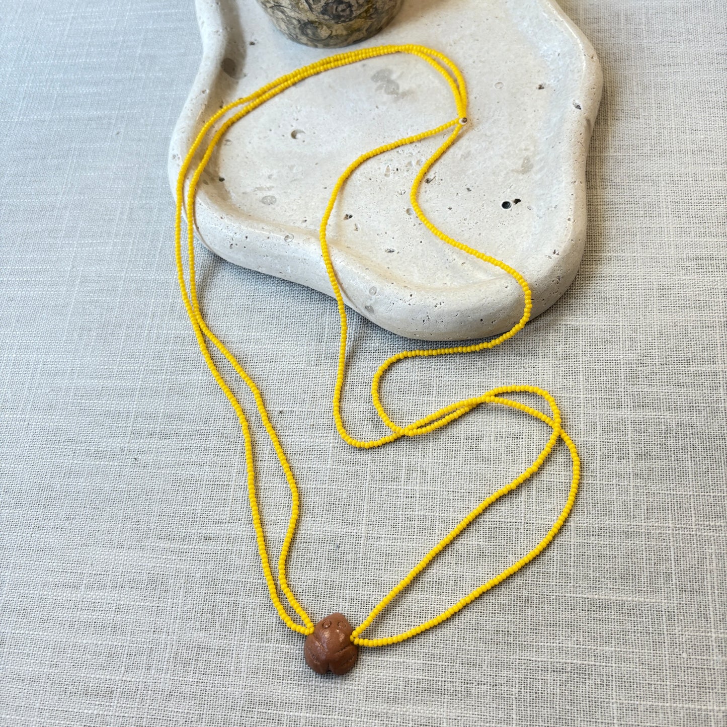 Collier en perles de verre (Miçanga) - jaune et pendentif Muiraquitã - Ethnie Borari