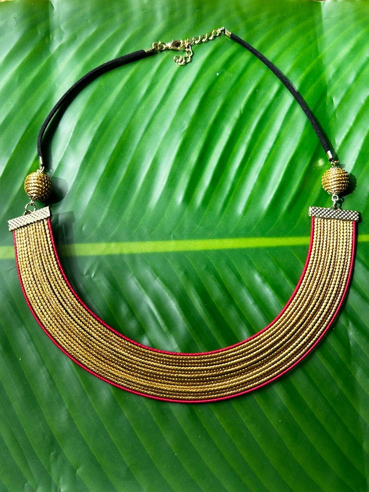 Collier Capim Dourado orné d'une bordure en fibre de palmier buriti teintée en rouge