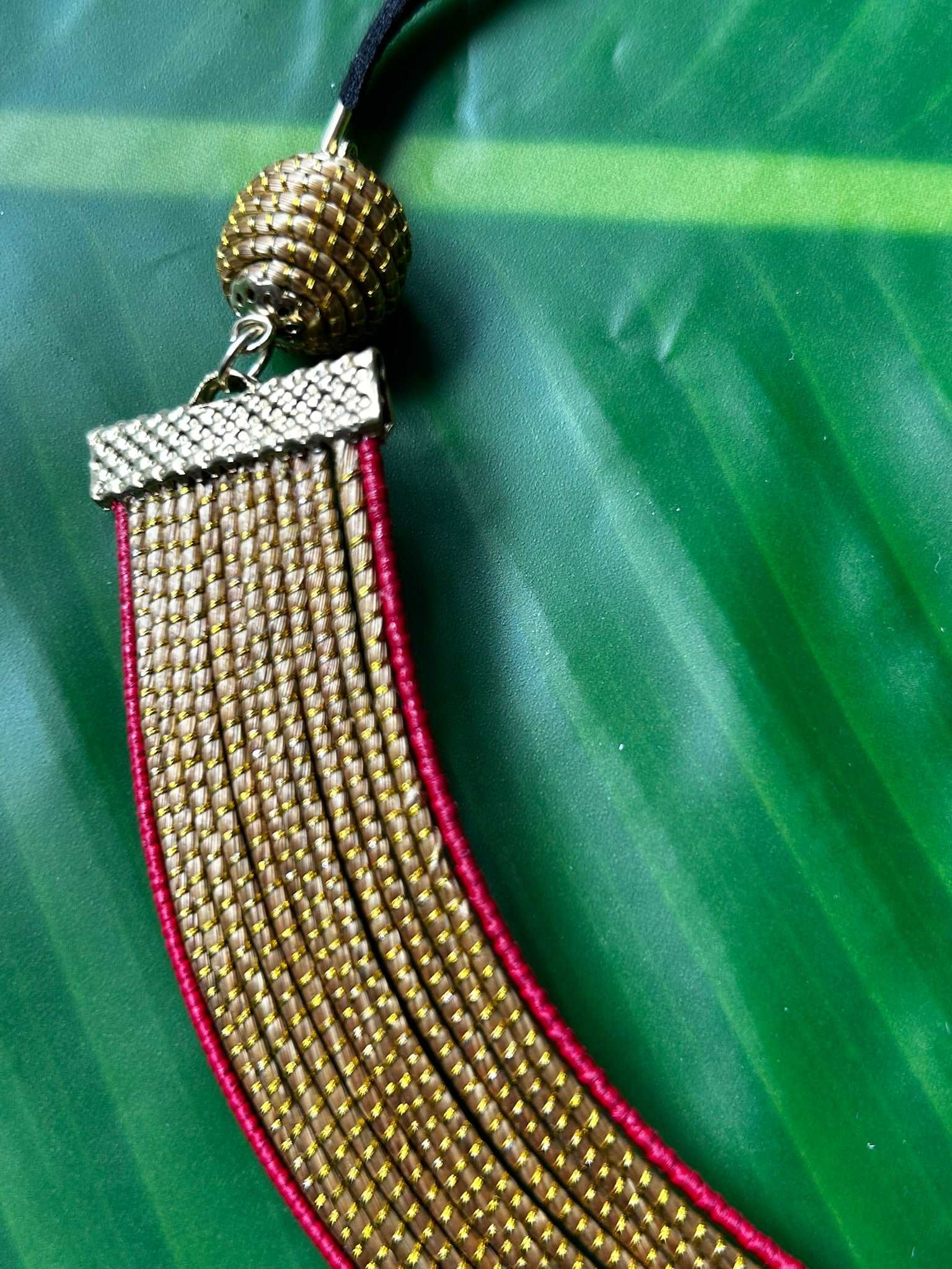 Collier Capim Dourado orné d'une bordure en fibre de palmier buriti teintée en rouge