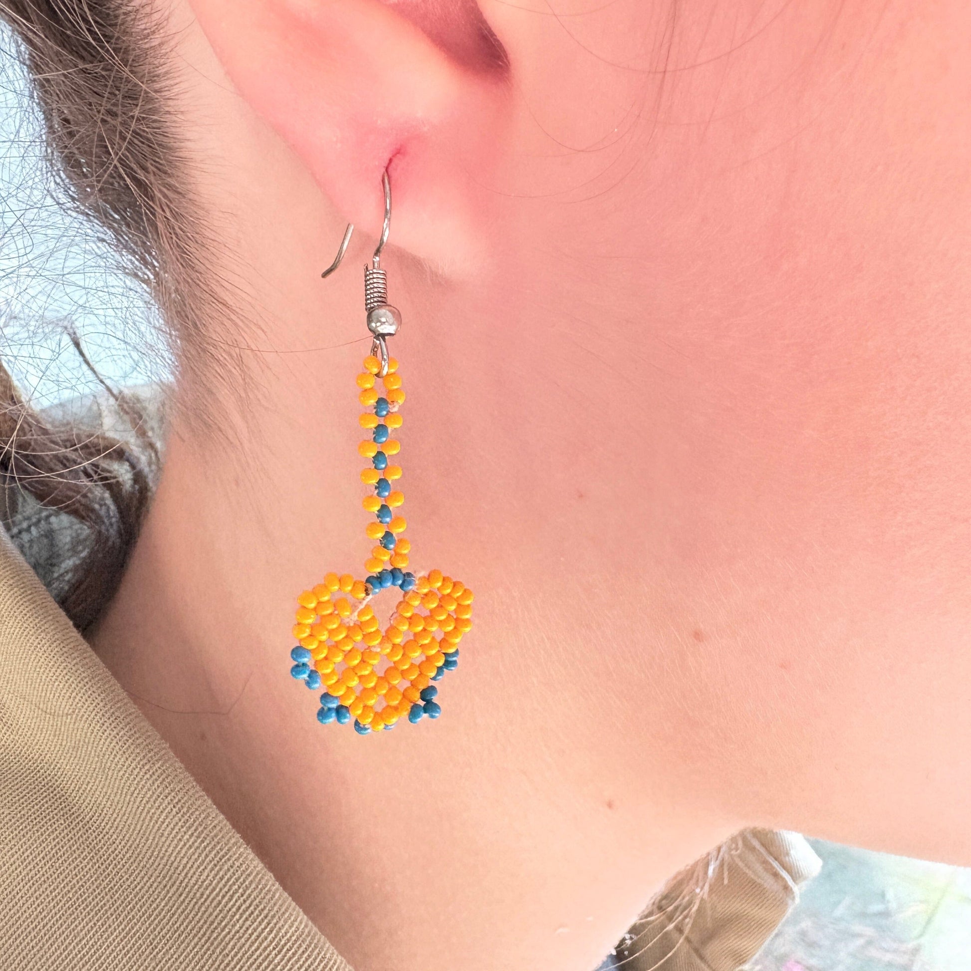 Boucles d'oreilles en perles de verre - Cœur orange et bleu - Ethnie Marubo Boucles d'oreilles Ethnie Marubo, localisée dans l'état d'Amazonas au nord du Brésil. 