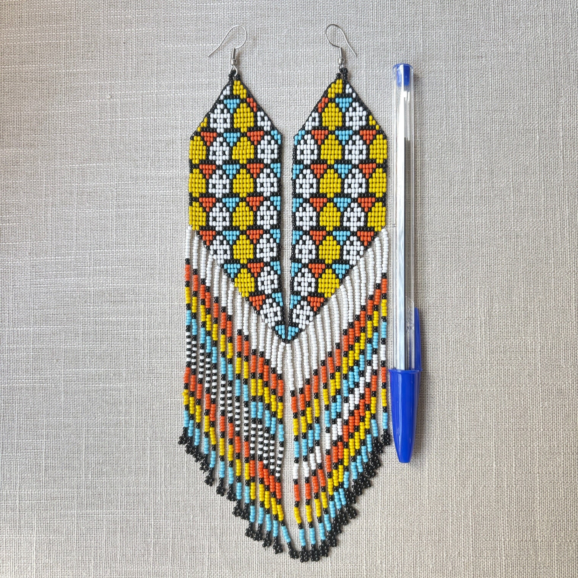 Boucles d'oreilles en perles de verre - Franges bleu jaune blanc noir - Ethnie Galibi-Marworno Boucles d'oreilles Ethnie Galibi-Marworno, localisée dans l'état d'Amapa au nord du Brésil. 