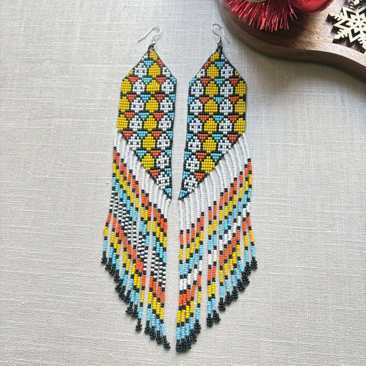 Boucles d'oreilles en perles de verre - Franges bleu jaune blanc noir - Ethnie Galibi-Marworno Boucles d'oreilles Ethnie Galibi-Marworno, localisée dans l'état d'Amapa au nord du Brésil. 