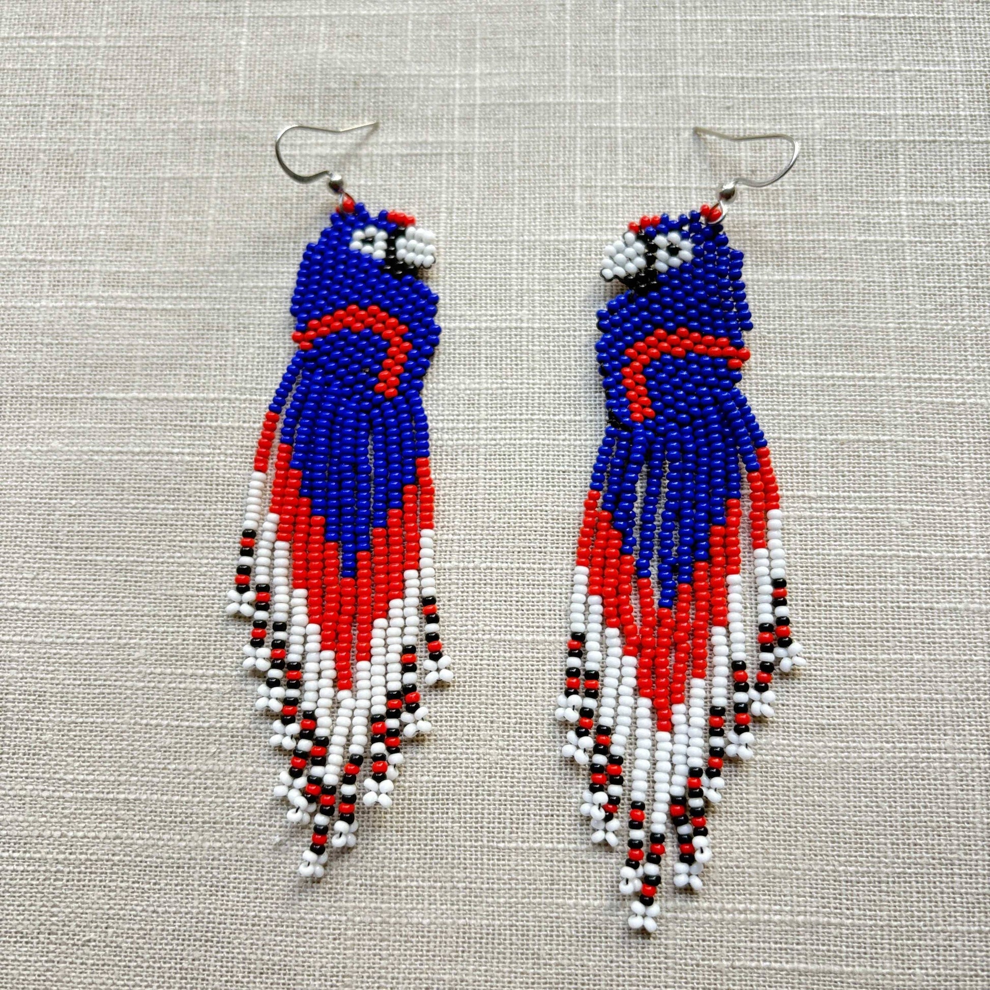 Boucles d'oreilles en perles de verre (Miçanga) - Ara bleu rouge blanc - Ethnie Borari Boucles d'oreilles Ethnie Borari, localisée dans l'état du Pará dans le Nord du Brésil. 