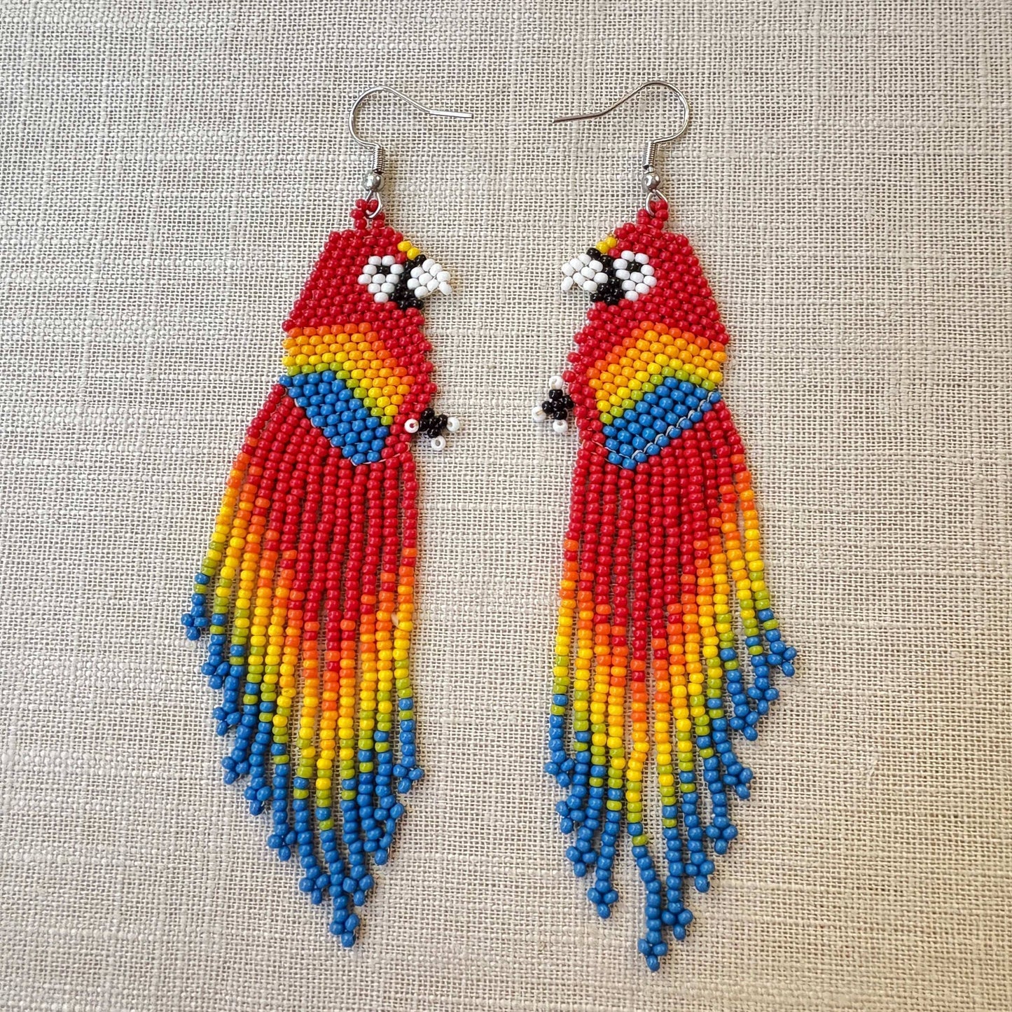Boucles d'oreilles en perles de verre (Miçanga) - Ara rouge - Ethnie Borari Boucles d'oreilles Ethnie Borari, localisée dans l'état du Pará dans le Nord du Brésil. 