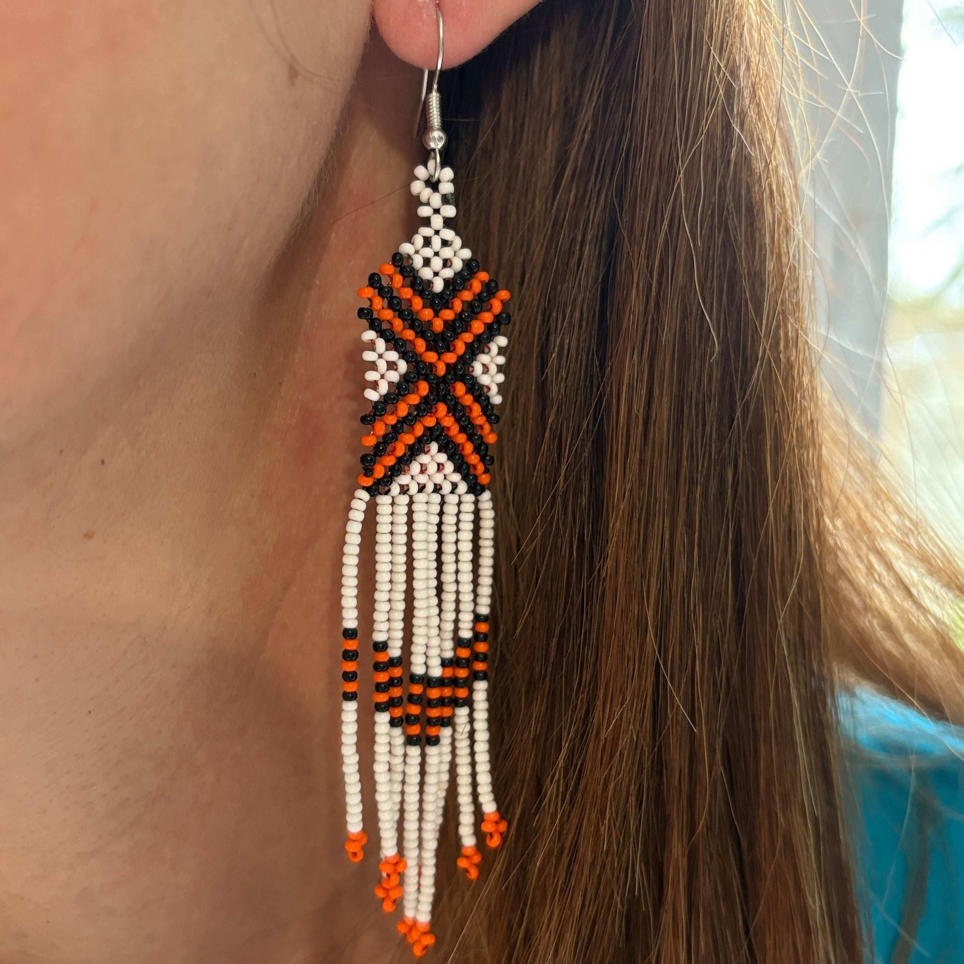Boucles d'oreilles en perles de verre (miçanga) - blanc croix noir et orange - Ethnie Wai Wai Boucles d'oreilles Ethnie Wai Wai localisée dans les états de l' Amazonas, Pará et Roraima dans le Nord du Brésil. 