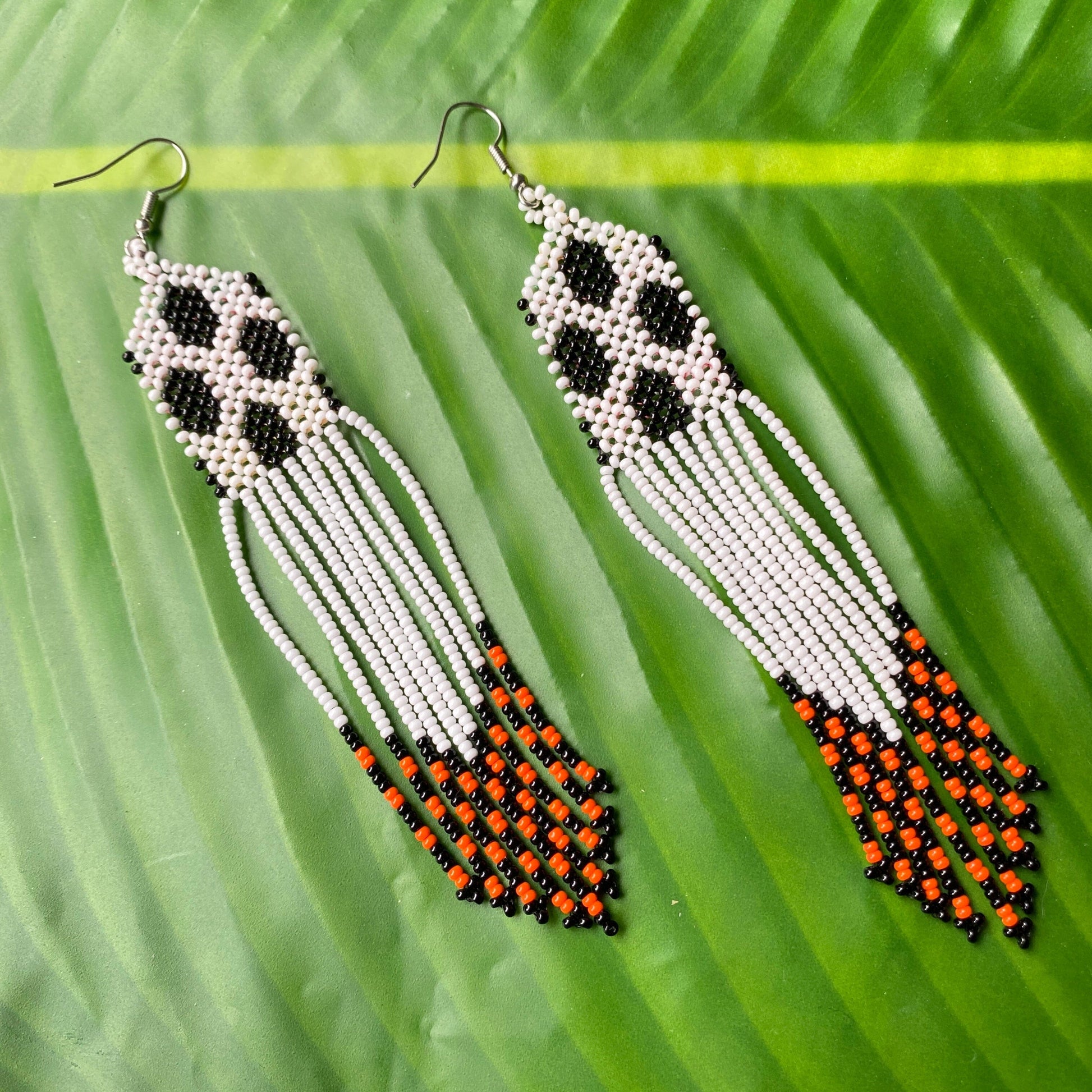 Boucles d'oreilles en perles de verre (miçanga) - Blanc et noir - Pointe orange et noir- Ethnie Wai Wai Boucles d'oreilles Ethnie Wai Wai localisée dans les états de l' Amazonas, Pará et Roraima dans le Nord du Brésil. 