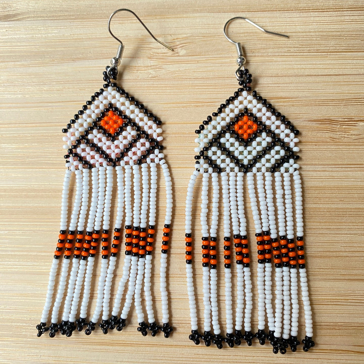 Boucles d'oreilles en perles de verre (miçanga) - Blanc noir et orange - Ethnie Wai Wai Boucles d'oreilles Ethnie Wai Wai localisée dans les états de l' Amazonas, Pará et Roraima dans le Nord du Brésil. 