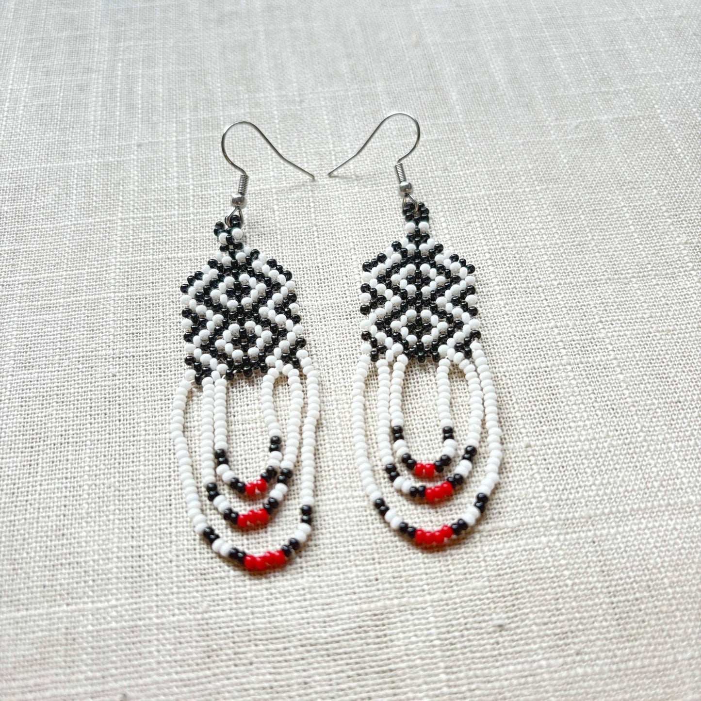 Boucles d'oreilles en perles de verre (Miçanga) - blanc noir et rouge - Ethnie Kayapo Boucles d'oreilles Ethnie Kayapo, localisée dans l'état du Pará au nord du Brésil 