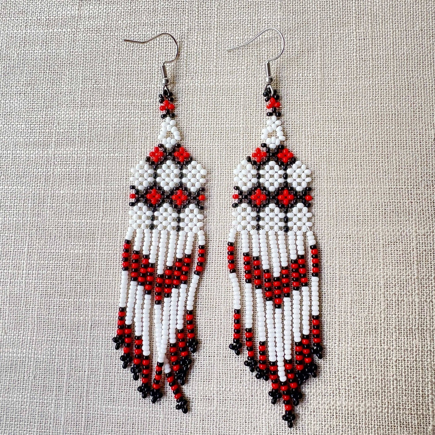 Boucles d'oreilles en perles de verre (Miçanga) - blanc noir rouge - Ethnie Kayapo Boucles d'oreilles Ethnie Kayapo, localisée dans l'état du Pará au nord du Brésil 