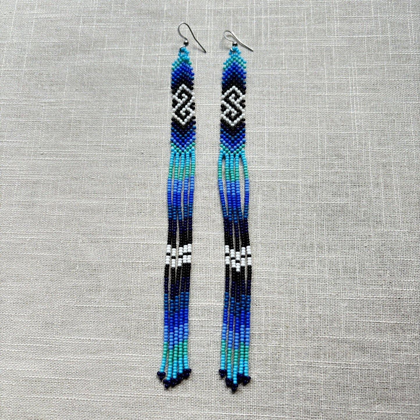 Boucles d'oreilles en perles de verre (Miçanga) - Bleu noir blanc à franges - Ethnie Borari Boucles d'oreilles Ethnie Borari, localisée dans l'état du Pará dans le Nord du Brésil. 