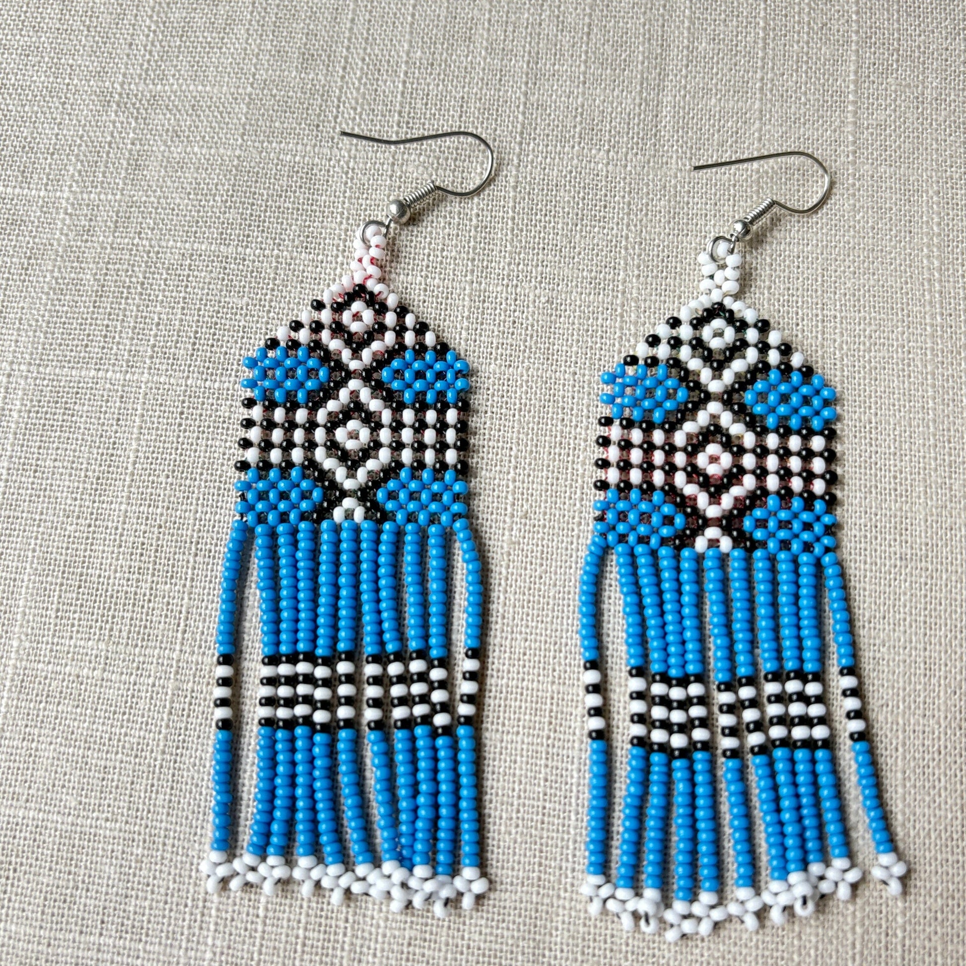 Boucles d'oreilles en perles de verre (miçanga) - Bleu noir et blanc - Ethnie Wai Wai Boucles d'oreilles Ethnie Wai Wai localisée dans les états de l' Amazonas, Pará et Roraima dans le Nord du Brésil. 