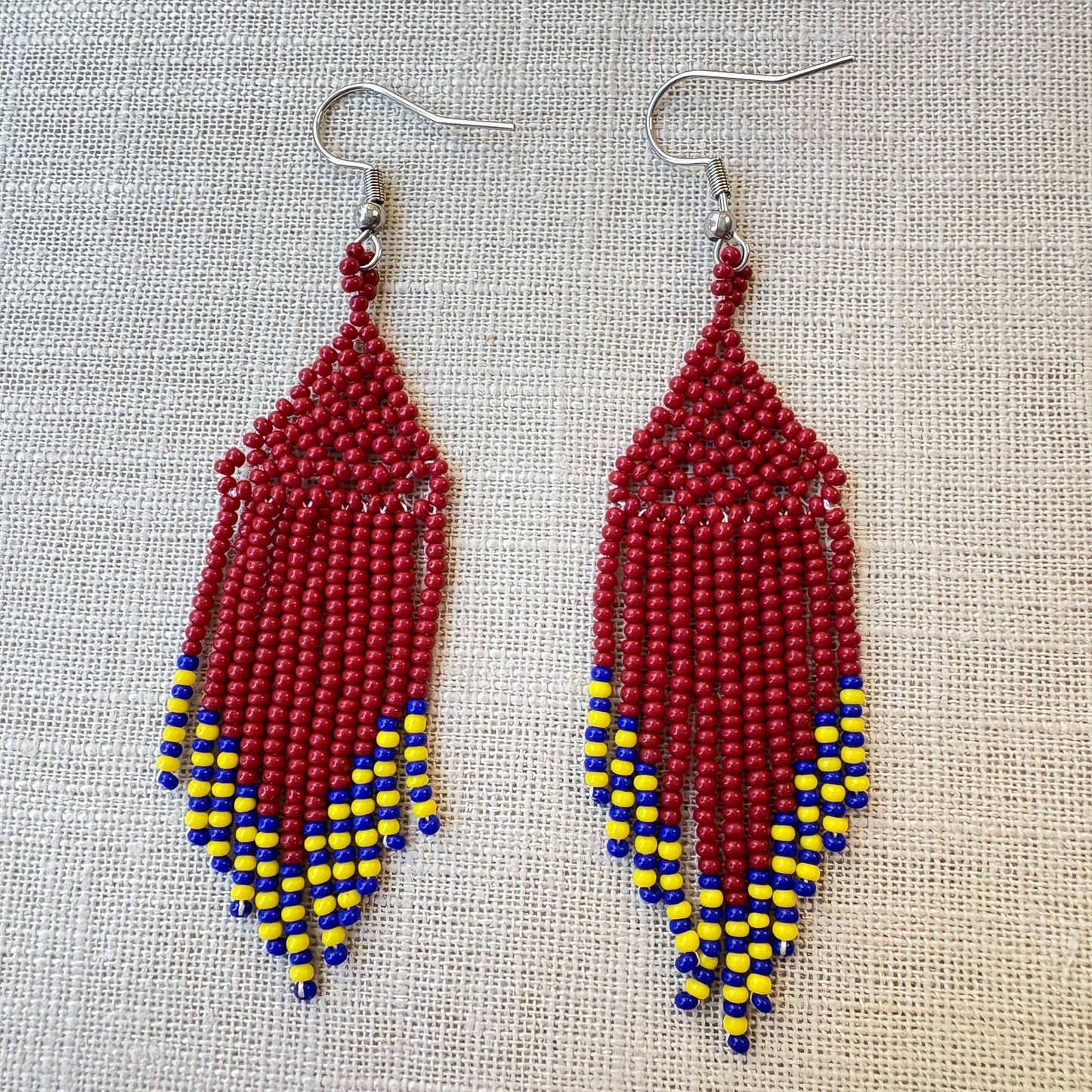 Boucles d'oreilles en perles de verre (Miçanga) - bordeaux jaune et bleu - Ethnie Kayapo Boucles d'oreilles Ethnie Kayapo, localisée dans l'état du Pará au nord du Brésil 
