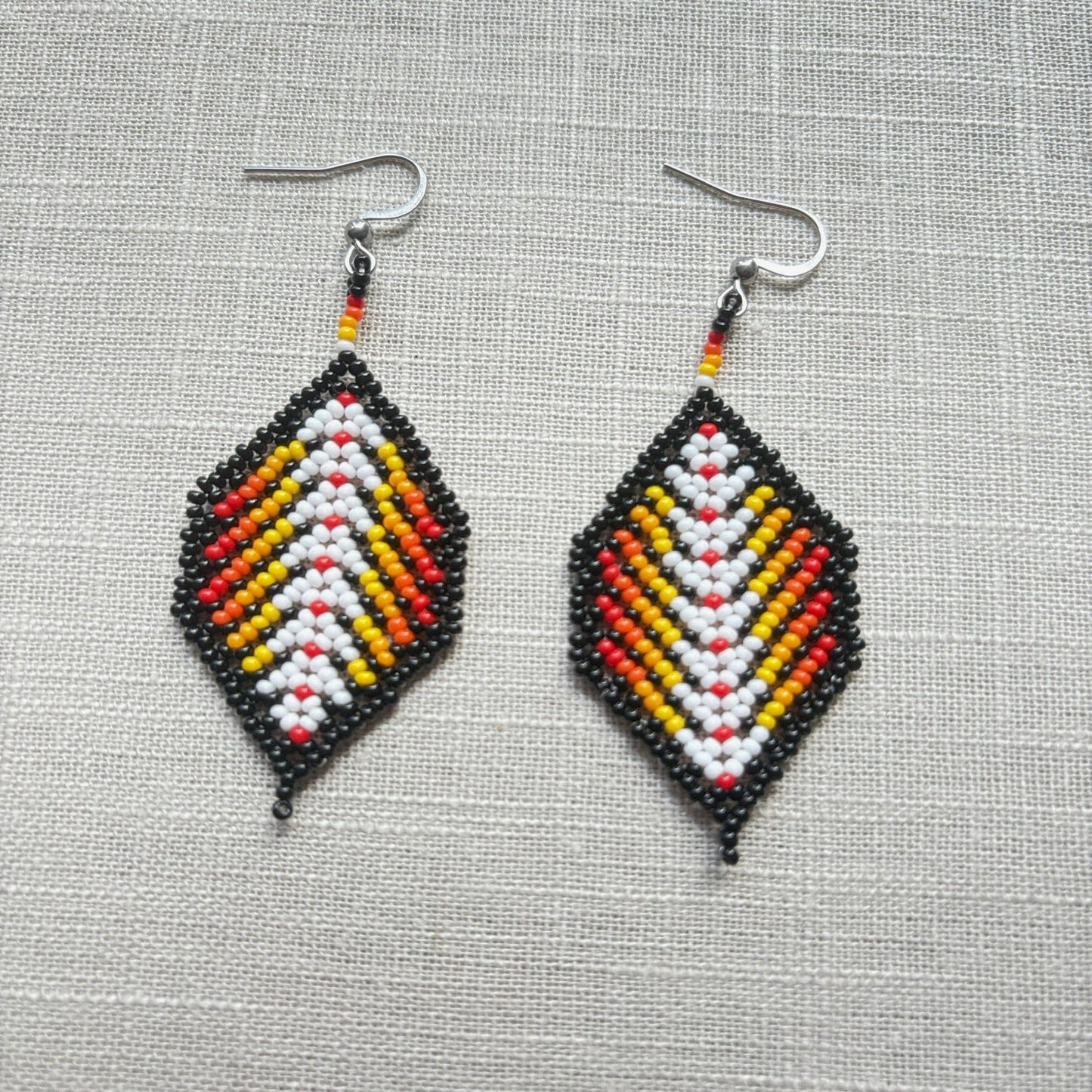 Boucles d'oreilles en perles de verre (Miçanga) - Feuilles noir rouge blanc - Ethnie Borari Boucles d'oreilles Ethnie Borari, localisée dans l'état du Pará dans le Nord du Brésil. 