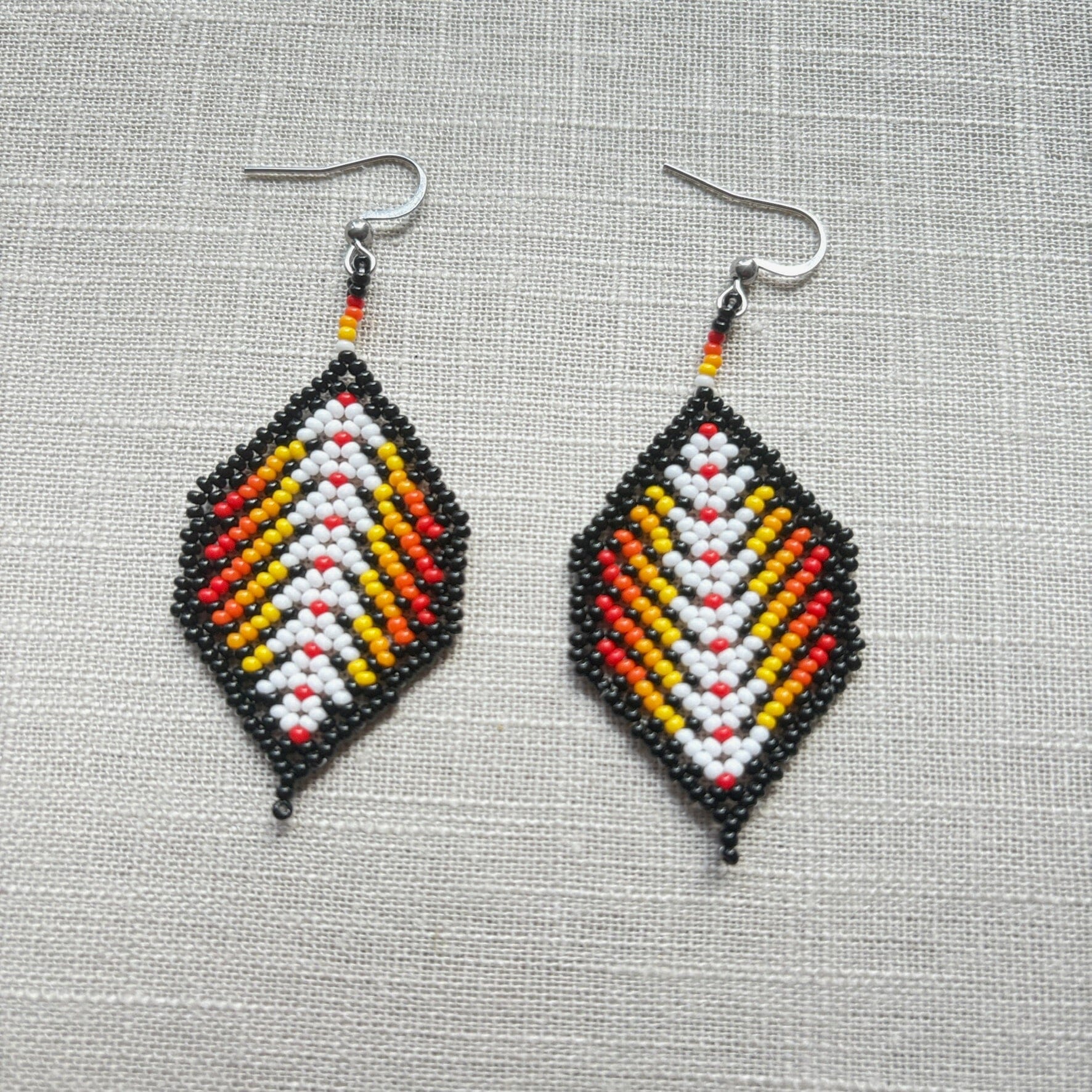 Boucles d'oreilles en perles de verre (Miçanga) - Feuilles noir rouge blanc - Ethnie Borari Boucles d'oreilles Ethnie Borari, localisée dans l'état du Pará dans le Nord du Brésil. 
