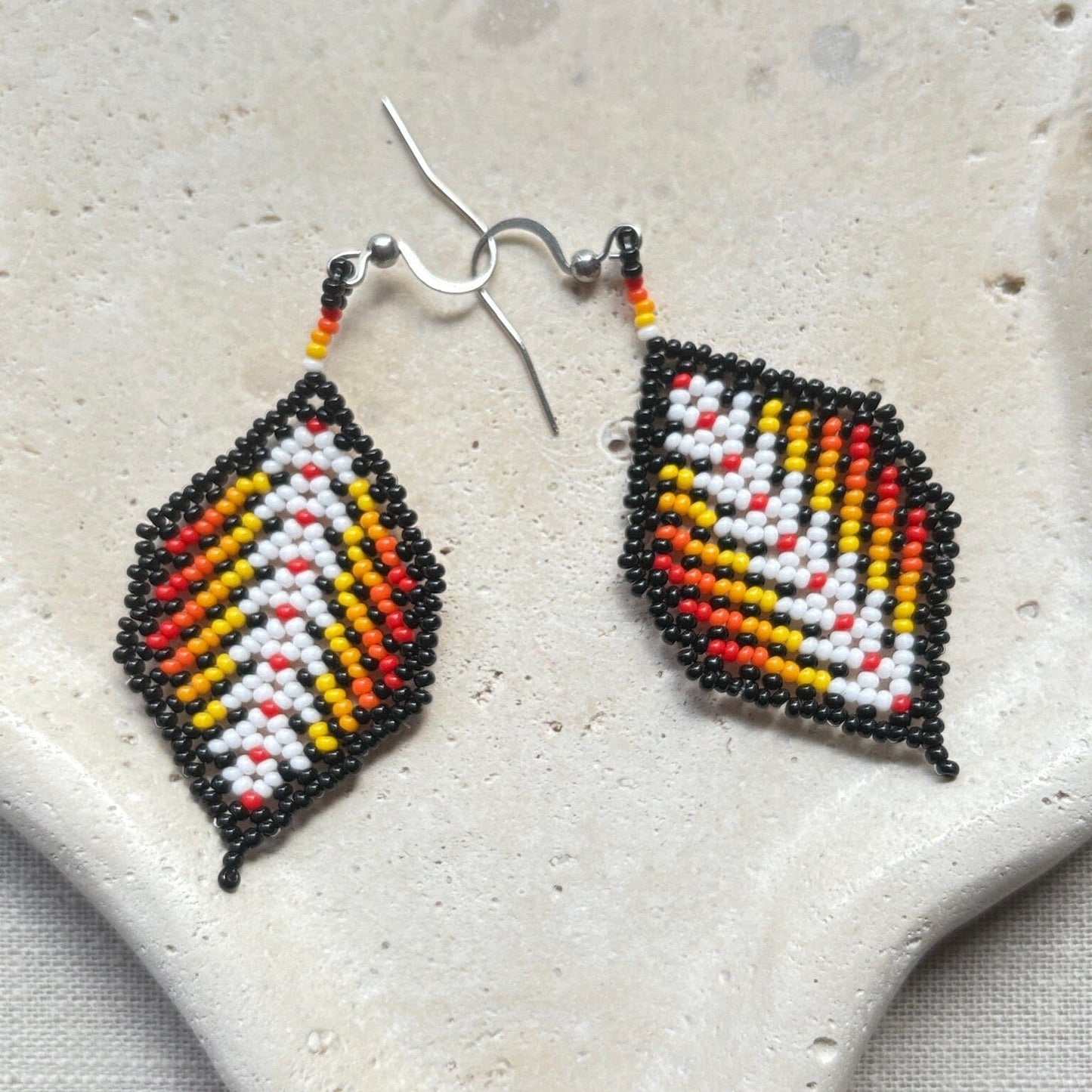 Boucles d'oreilles en perles de verre (Miçanga) - Feuilles noir rouge blanc - Ethnie Borari Boucles d'oreilles Ethnie Borari, localisée dans l'état du Pará dans le Nord du Brésil. 