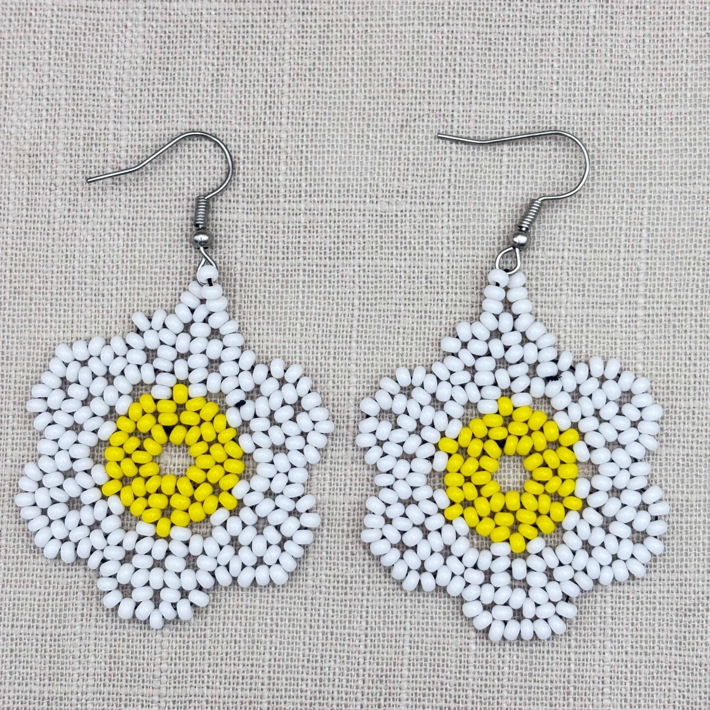 Boucles d'oreilles en perles de verre (miçanga) - Fleur blanche grand coeur jaune - Ethnie Wai Wai Boucles d'oreilles Ethnie Wai Wai localisée dans les états de l' Amazonas, Pará et Roraima dans le Nord du Brésil. 