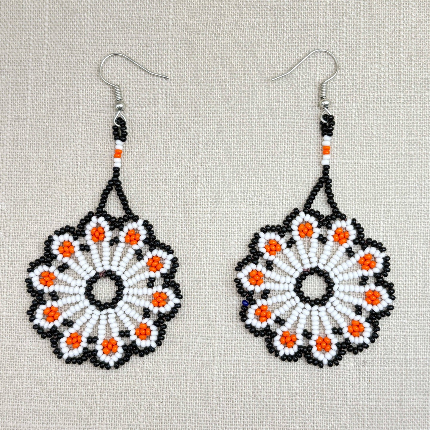 Boucles d'oreilles en perles de verre (miçanga) - Fleur blanche orange et noire - Ethnie Wai Wai Boucles d'oreilles Ethnie Wai Wai localisée dans les états de l' Amazonas, Pará et Roraima dans le Nord du Brésil. 