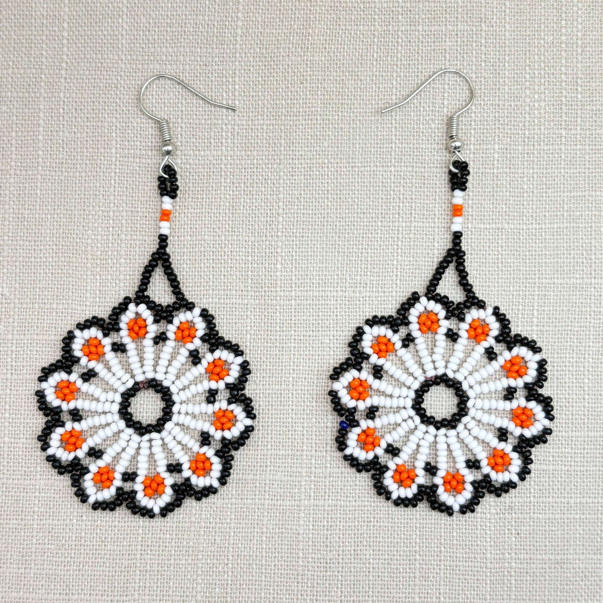 Boucles d'oreilles en perles de verre (miçanga) - Fleur blanche orange et noire - Ethnie Wai Wai Boucles d'oreilles Ethnie Wai Wai localisée dans les états de l' Amazonas, Pará et Roraima dans le Nord du Brésil. 
