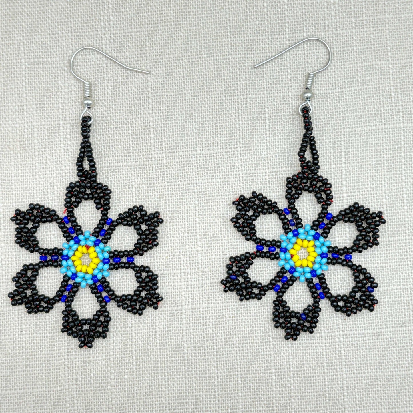 Boucles d'oreilles en perles de verre (miçanga) - Fleur noire et bleue coeur jaune - Ethnie Wai Wai Boucles d'oreilles Ethnie Wai Wai localisée dans les états de l' Amazonas, Pará et Roraima dans le Nord du Brésil. 