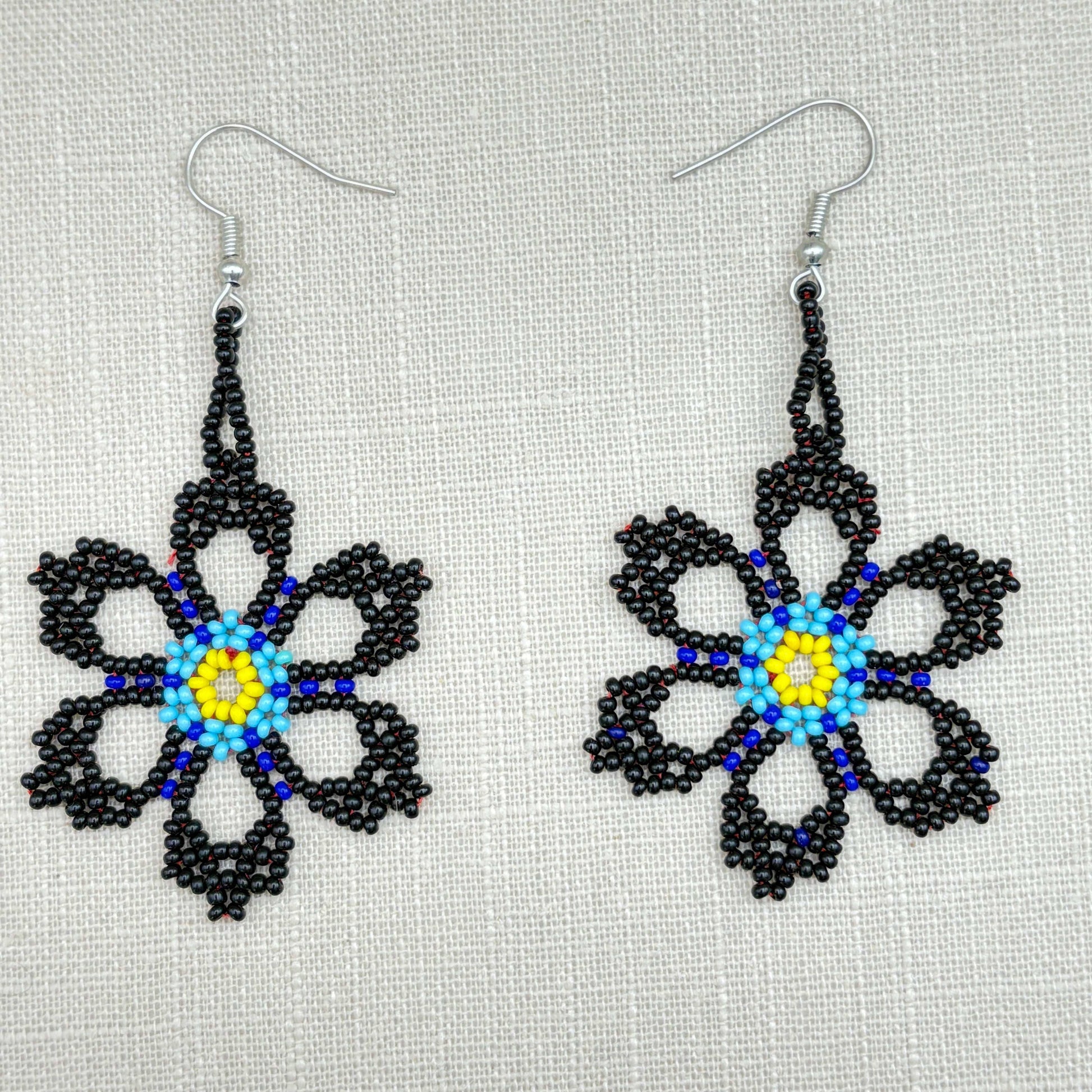 Boucles d'oreilles en perles de verre (miçanga) - Fleur noire et bleue coeur jaune - Ethnie Wai Wai Boucles d'oreilles Ethnie Wai Wai localisée dans les états de l' Amazonas, Pará et Roraima dans le Nord du Brésil. 