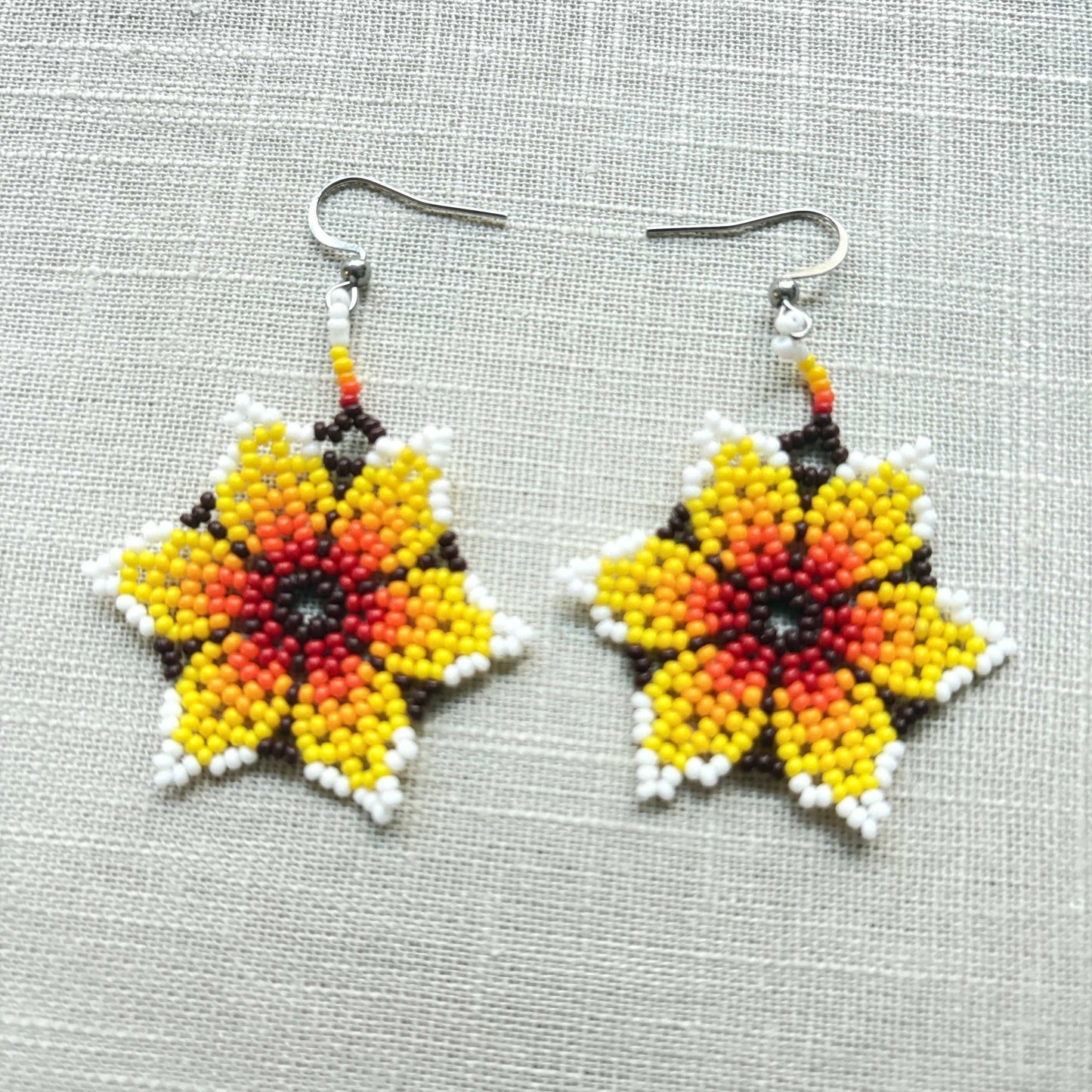 Boucles d'oreilles en perles de verre (Miçanga) - Fleur rouge orange blanc et noir - Ethnie Borari Boucles d'oreilles Ethnie Borari, localisée dans l'état du Pará dans le Nord du Brésil. 