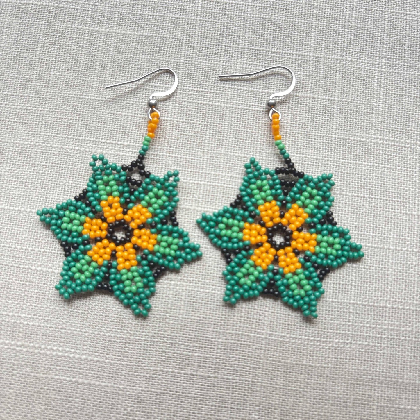 Boucles d'oreilles en perles de verre (Miçanga) - Fleur vert noir et orange - Ethnie Borari Boucles d'oreilles Ethnie Borari, localisée dans l'état du Pará dans le Nord du Brésil. 