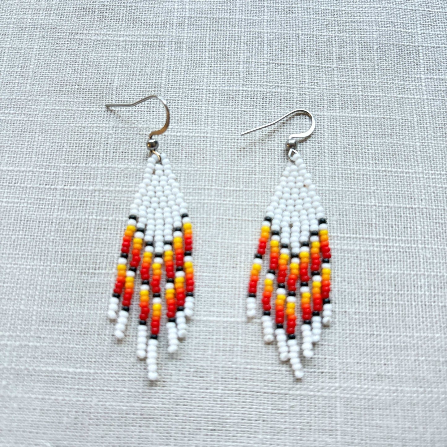 Boucles d'oreilles en perles de verre (Miçanga) - Franges blanc rouge orange - Ethnie Borari Boucles d'oreilles Ethnie Borari, localisée dans l'état du Pará dans le Nord du Brésil. 