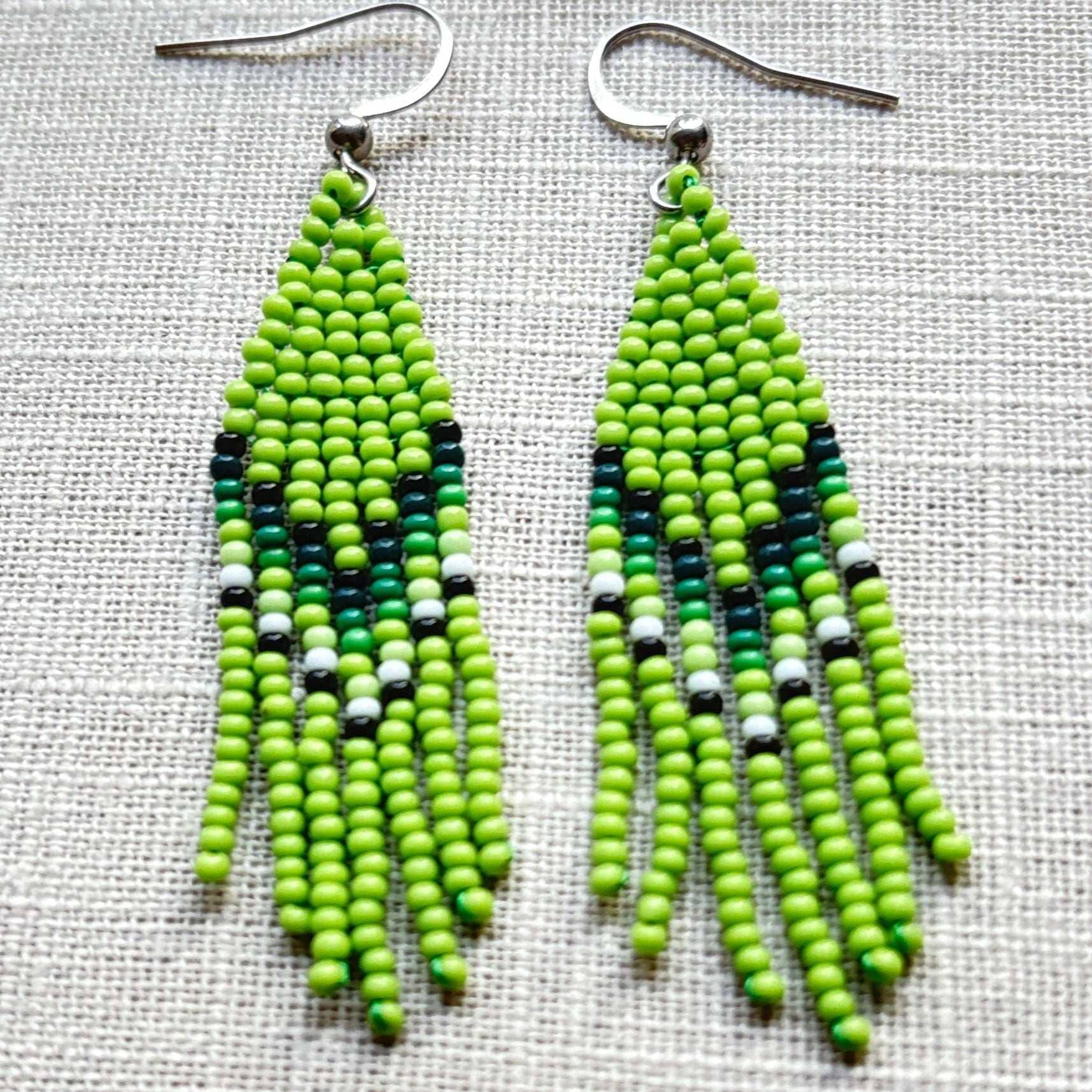 Boucles d'oreilles en perles de verre (Miçanga) - Franges vert blanc - Ethnie Borari Boucles d'oreilles Ethnie Borari, localisée dans l'état du Pará dans le Nord du Brésil. 