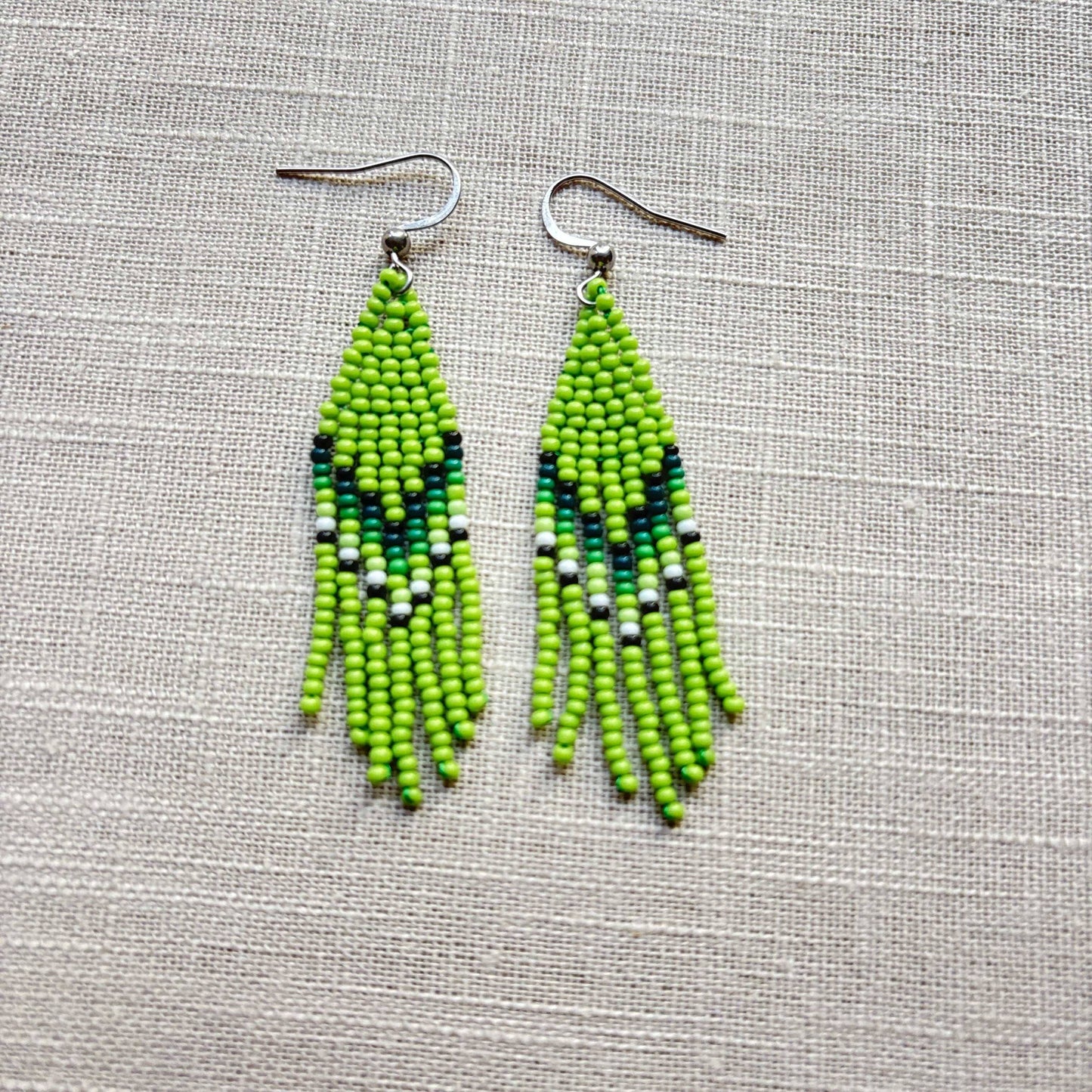 Boucles d'oreilles en perles de verre (Miçanga) - Franges vert blanc - Ethnie Borari Boucles d'oreilles Ethnie Borari, localisée dans l'état du Pará dans le Nord du Brésil. 