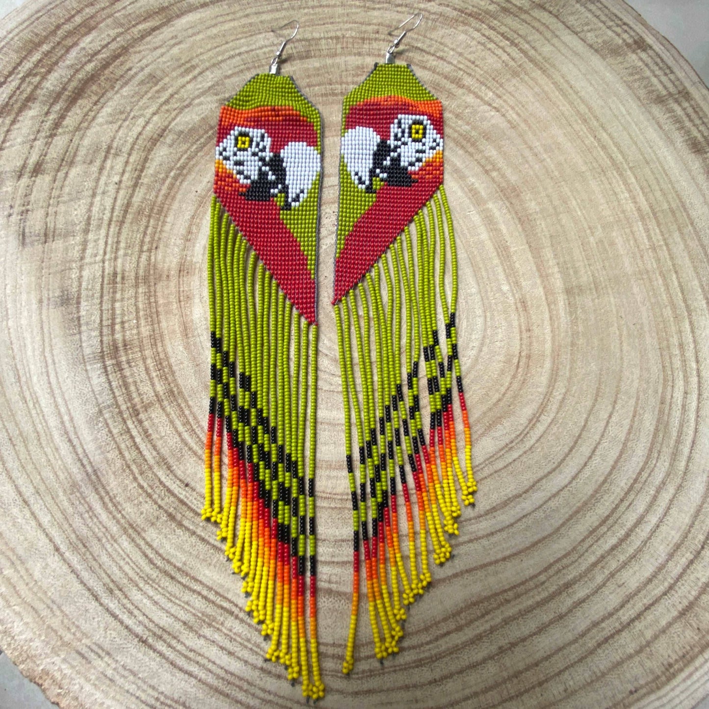 Boucles d'oreilles en perles de verre (miçanga) - Motif Ara rouge fond vert - Ethnie Wai Wai Boucles d'oreilles Ethnie Wai Wai localisée dans les états de l' Amazonas, Pará et Roraima dans le Nord du Brésil. 